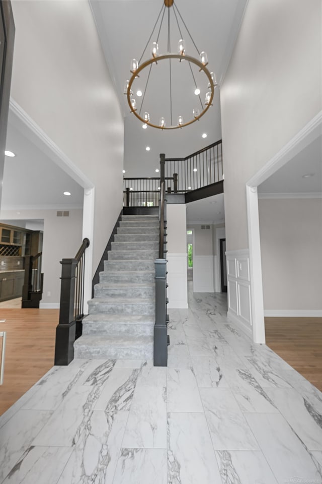 835 Crestwood Ln, Rochester Hills, MI 48309 - stairs featuring a high ceiling, a chandelier, recessed lighting, ornamental molding, and wood finished floors