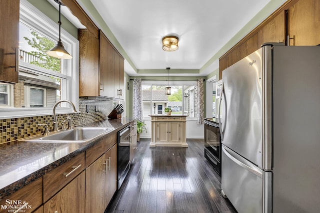 kitchen with freestanding refrigerator, dishwashing machine, a sink, backsplash, and dark wood-type flooring