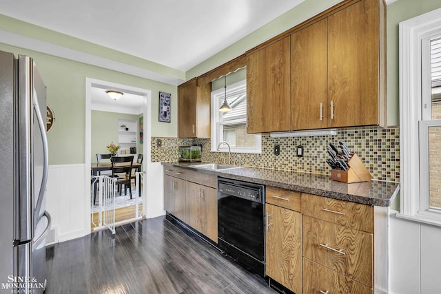 kitchen with freestanding refrigerator, black dishwasher, a sink, dark wood finished floors, and brown cabinetry