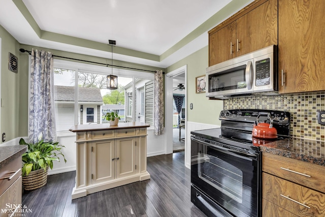 kitchen featuring stainless steel microwave, black range with electric cooktop, decorative backsplash, and dark wood-style flooring