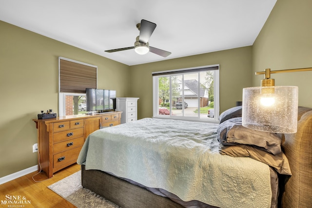 bedroom featuring light wood-style floors, baseboards, and a ceiling fan