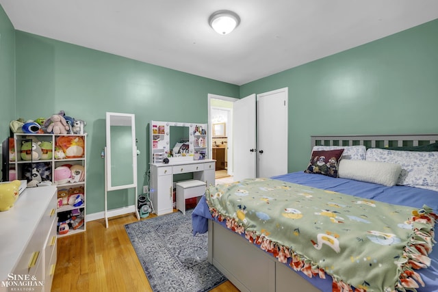bedroom featuring light wood-style floors and baseboards