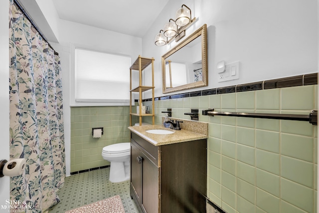bathroom featuring tile walls, toilet, vanity, a wainscoted wall, and a shower with shower curtain
