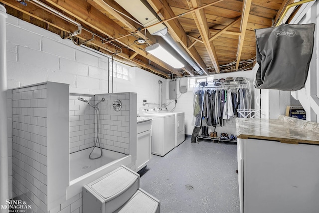 below grade area featuring independent washer and dryer, concrete block wall, and electric panel