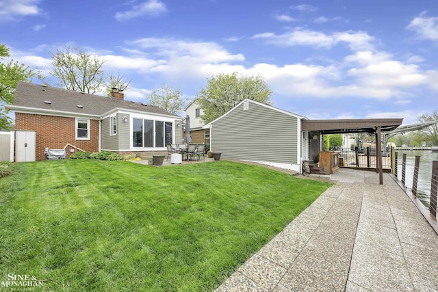 back of property with a patio area, a chimney, a gate, and brick siding