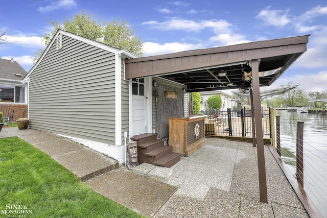 view of outdoor structure featuring entry steps, fence, and a water view