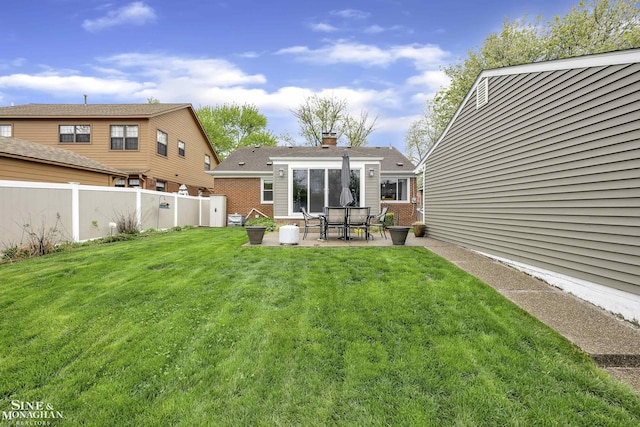back of property with brick siding, a patio, and a chimney