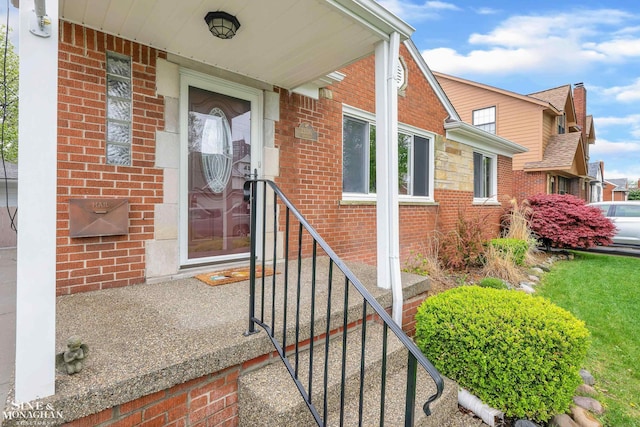 doorway to property featuring brick siding