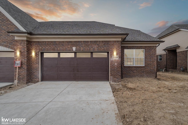 21168 Lilac Ln, Clinton Township, MI 48036 - view of front of house featuring concrete driveway, brick siding, an attached garage, and a shingled roof