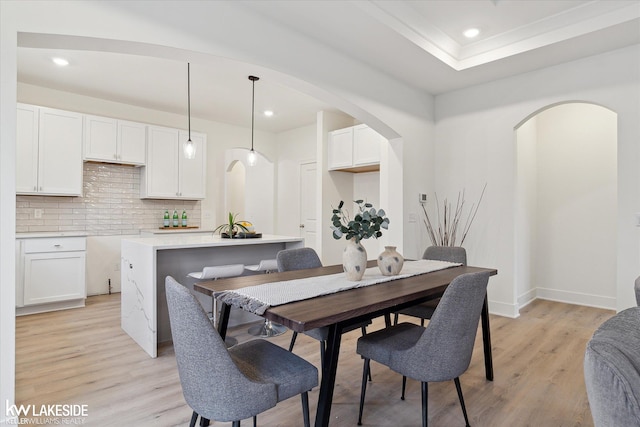 21168 Lilac Ln, Clinton Township, MI 48036 - dining room featuring arched walkways, light wood-style flooring, recessed lighting, and baseboards