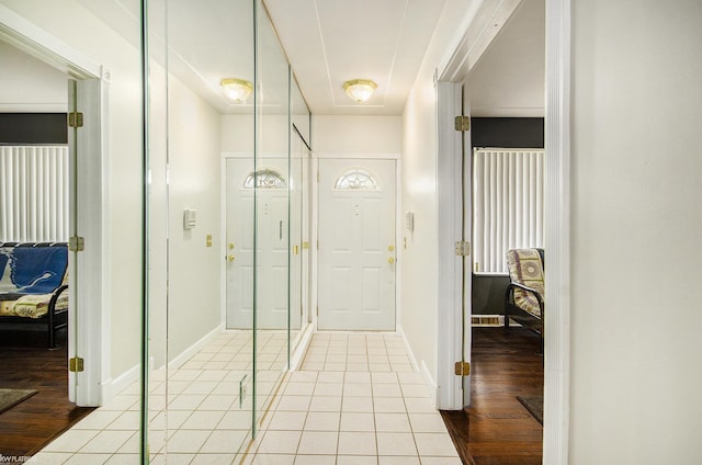 hallway with light tile patterned flooring and baseboards