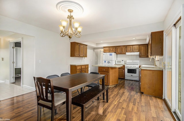 dining space featuring dark wood finished floors, a chandelier, baseboards, and recessed lighting