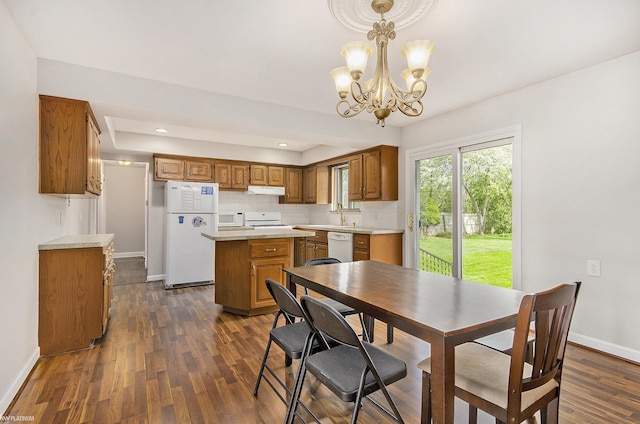 dining space featuring a chandelier, dark wood-type flooring, baseboards, and recessed lighting