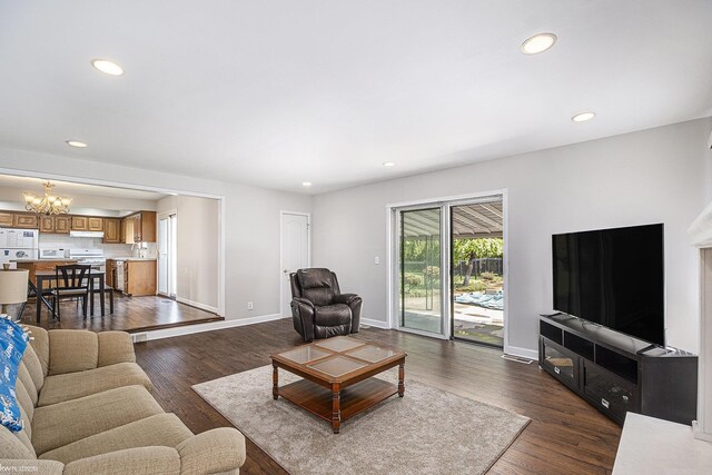 living area featuring a chandelier, recessed lighting, dark wood finished floors, and baseboards