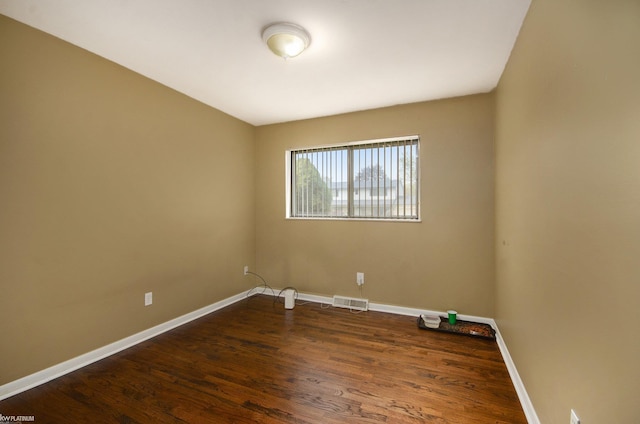 unfurnished room with dark wood-style flooring and baseboards