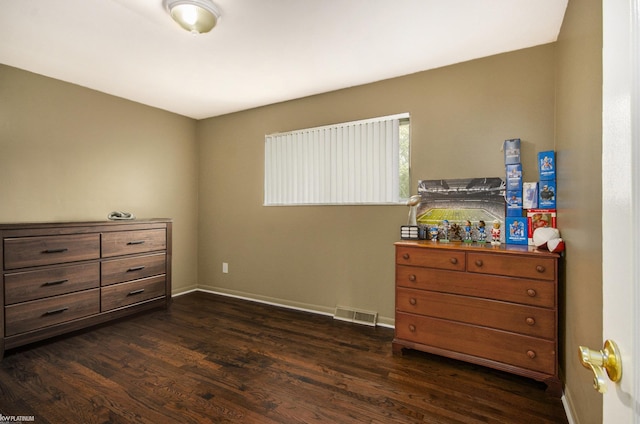 bedroom with dark wood-type flooring and baseboards