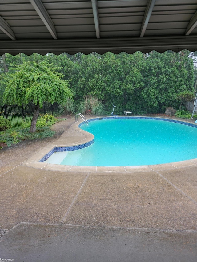 view of pool with fence and a patio