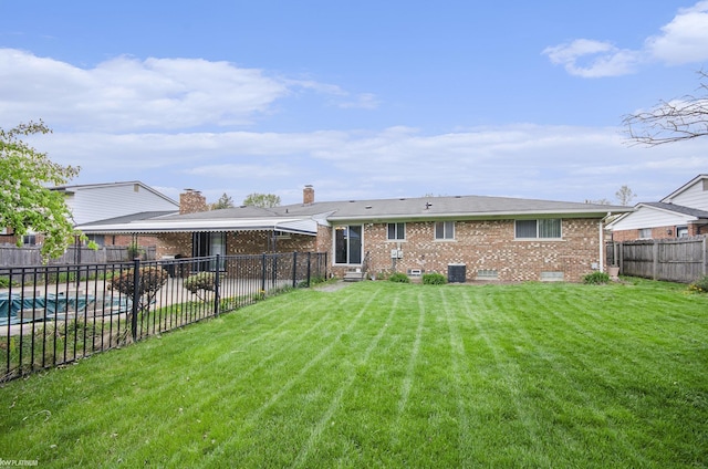 rear view of house with brick siding, a chimney, entry steps, and central AC