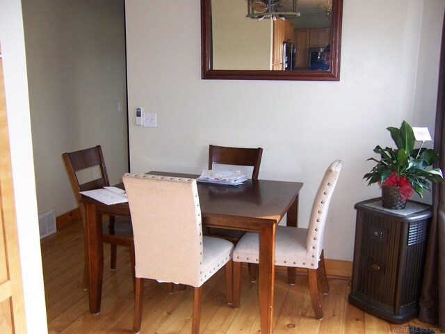 dining area featuring light wood-style flooring and a chandelier