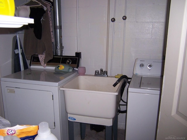 laundry area featuring washer and dryer and concrete block wall