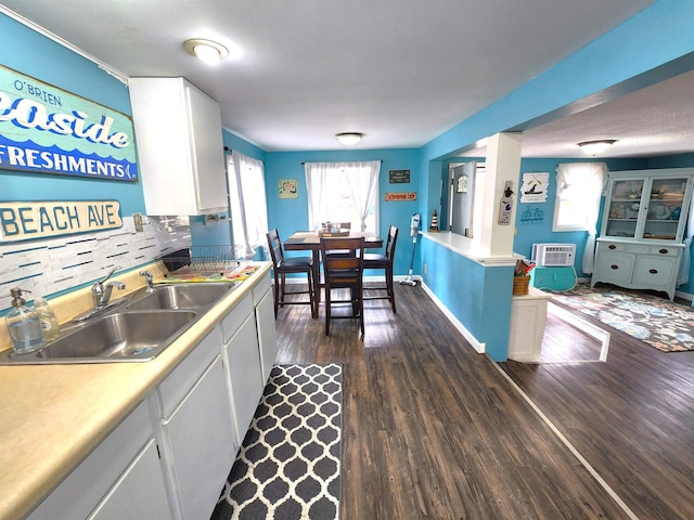 6494 Birch St, Gladwin, MI 48624 - kitchen featuring a sink, white cabinetry, dark wood-style flooring, light countertops, and tasteful backsplash
