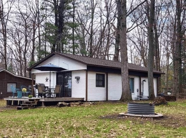 6494 Birch St, Gladwin, MI 48624 - ranch-style house with a wooden deck and a front lawn