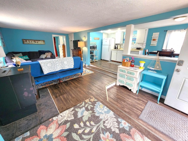 6494 Birch St, Gladwin, MI 48624 - bedroom with freestanding refrigerator, wood finished floors, and a textured ceiling