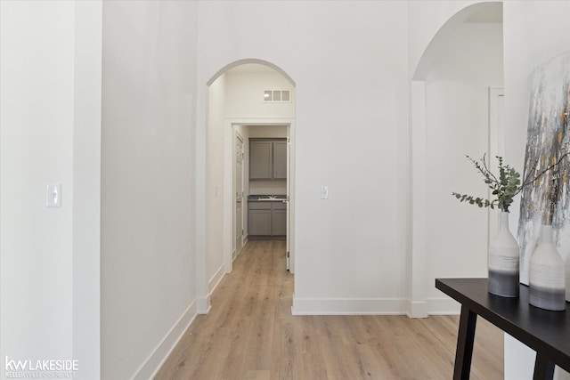 40699 Azalea Ln, Clinton Township, MI 48036 - hallway with light wood-style flooring, baseboards, and arched walkways