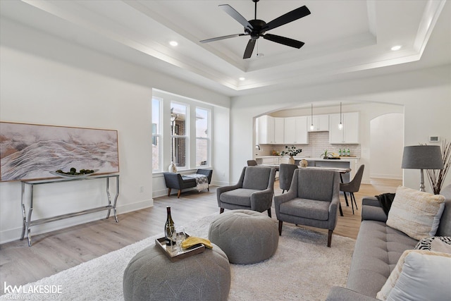 40699 Azalea Ln, Clinton Township, MI 48036 - living room with arched walkways, a raised ceiling, light wood-style flooring, ceiling fan, and recessed lighting