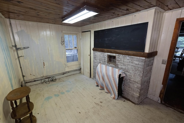 4440 W Cherry Creek Rd, Lewiston, MI 49756 - unfurnished living room with wooden walls, wood ceiling, hardwood / wood-style floors, and a baseboard heating unit