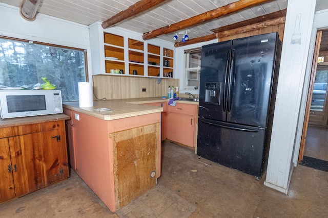 4440 W Cherry Creek Rd, Lewiston, MI 49756 - kitchen featuring black fridge, white microwave, beamed ceiling, open shelves, and light countertops