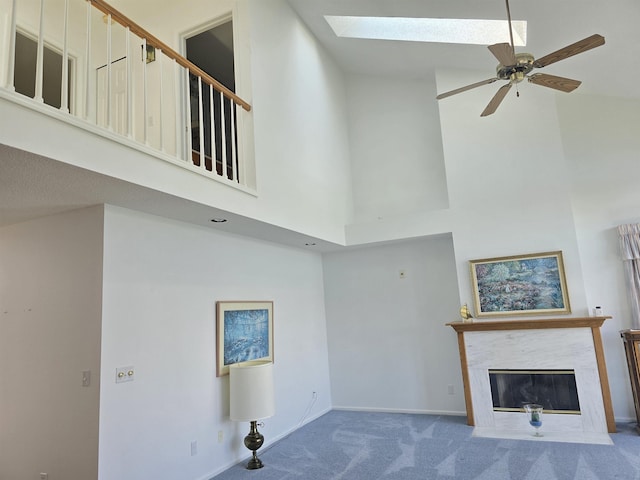2707 Inverness Dr, Bay City, MI 48706 - unfurnished living room with carpet flooring, a towering ceiling, a skylight, a ceiling fan, and a fireplace