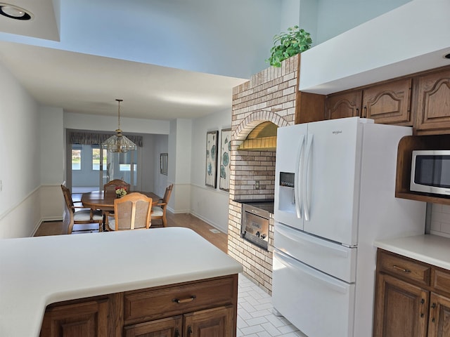 2707 Inverness Dr, Bay City, MI 48706 - kitchen featuring white fridge with ice dispenser, stainless steel microwave, decorative backsplash, and light countertops