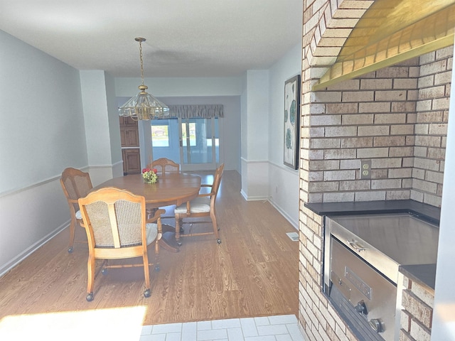 2707 Inverness Dr, Bay City, MI 48706 - dining room with a chandelier, wood finished floors, and baseboards