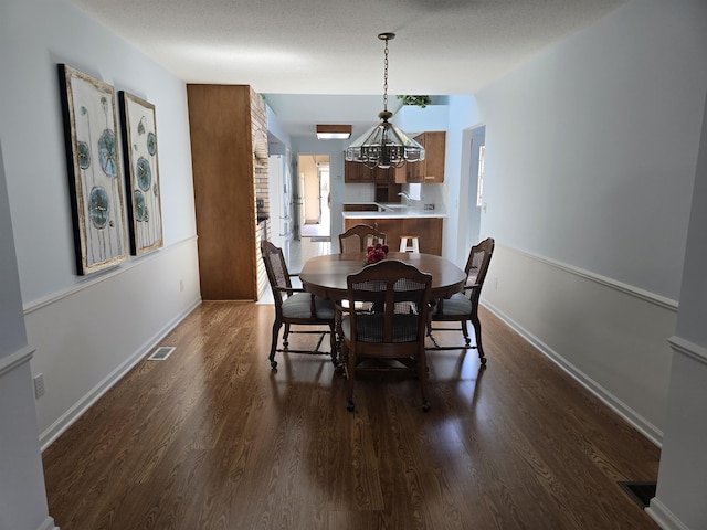 2707 Inverness Dr, Bay City, MI 48706 - dining space with a chandelier, dark wood-type flooring, and baseboards