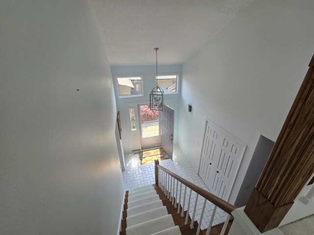 2707 Inverness Dr, Bay City, MI 48706 - stairs with a high ceiling, a chandelier, and wood finished floors