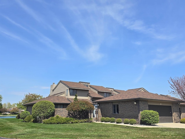 2707 Inverness Dr, Bay City, MI 48706 - view of front of property with brick siding, a front lawn, an attached garage, a chimney, and concrete driveway