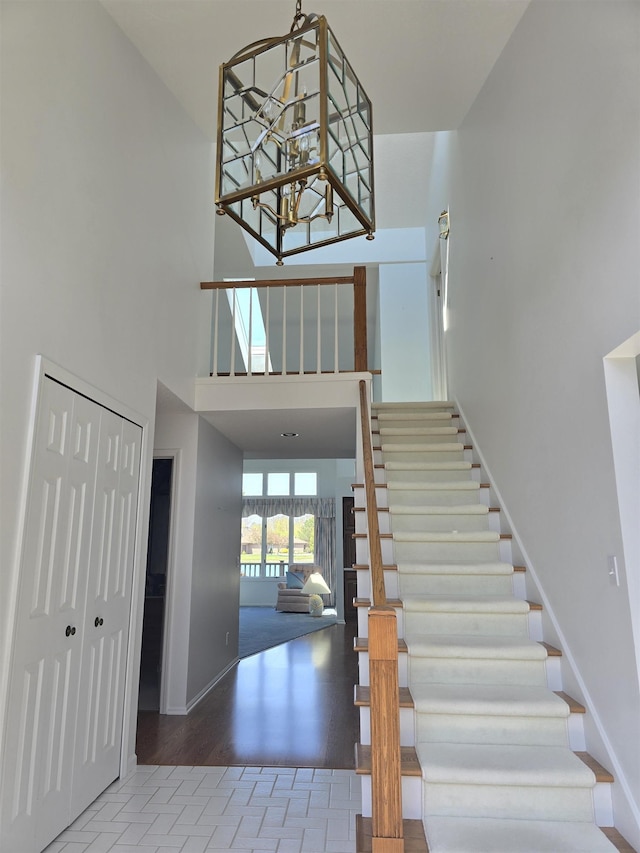 2707 Inverness Dr, Bay City, MI 48706 - entrance foyer featuring stairs, a chandelier, baseboards, a towering ceiling, and wood finished floors