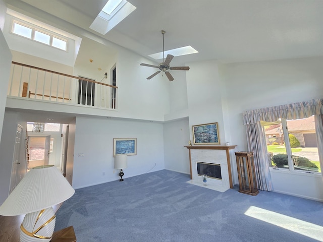2707 Inverness Dr, Bay City, MI 48706 - unfurnished living room with a skylight, carpet floors, a fireplace with flush hearth, high vaulted ceiling, and healthy amount of natural light