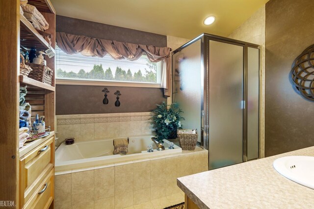 full bath featuring a stall shower, a garden tub, and vanity