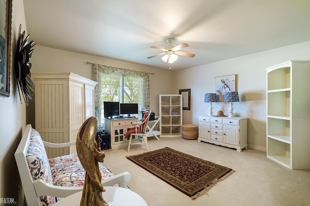 office featuring a ceiling fan and light carpet