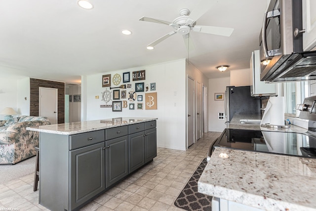 kitchen featuring ceiling fan, appliances with stainless steel finishes, a center island, recessed lighting, and gray cabinets