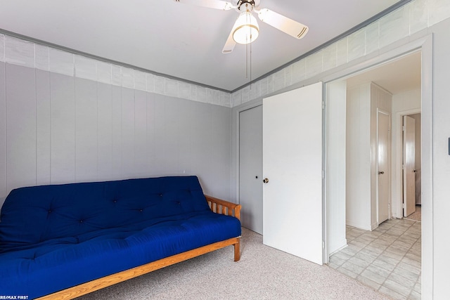 sitting room with ceiling fan and carpet flooring