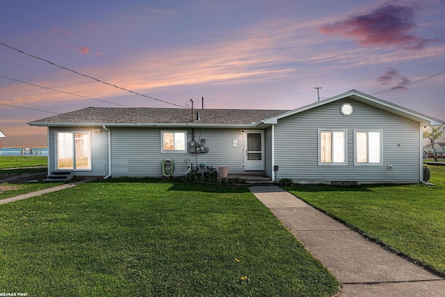 ranch-style house with a front lawn and a shingled roof