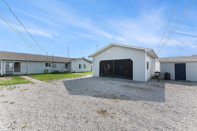 exterior space featuring an outdoor structure, a detached garage, and a front lawn