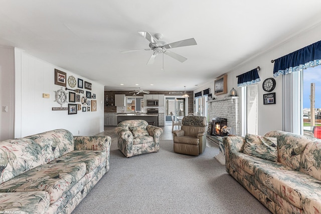 carpeted living area featuring ceiling fan and a brick fireplace