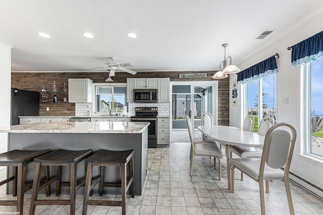 kitchen with appliances with stainless steel finishes, ceiling fan, recessed lighting, hanging light fixtures, and decorative backsplash