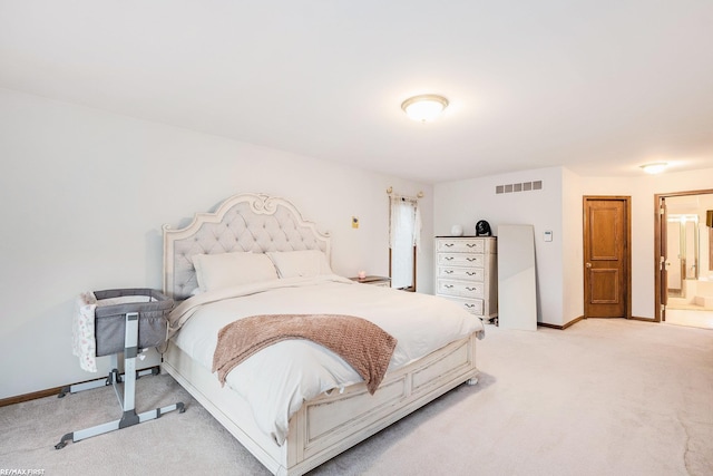 bedroom featuring light carpet, baseboards, and ensuite bathroom