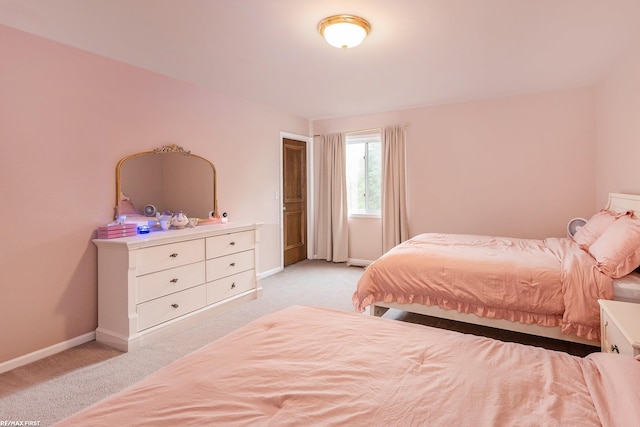bedroom featuring light colored carpet and baseboards