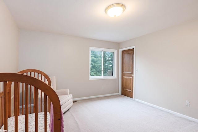 bedroom with baseboards and light colored carpet